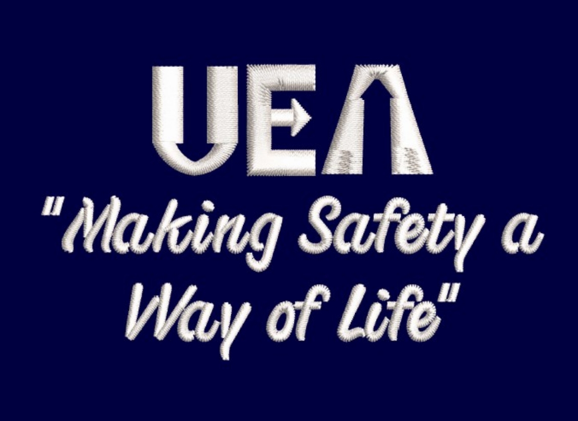 Picture of Embroidery of UEA in White with Wording Underneath "Making Safety A Way Of life"
